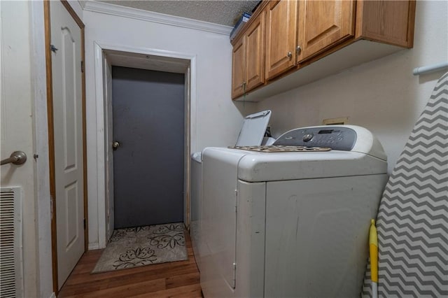 laundry area with washer and clothes dryer, cabinets, ornamental molding, a textured ceiling, and light hardwood / wood-style floors