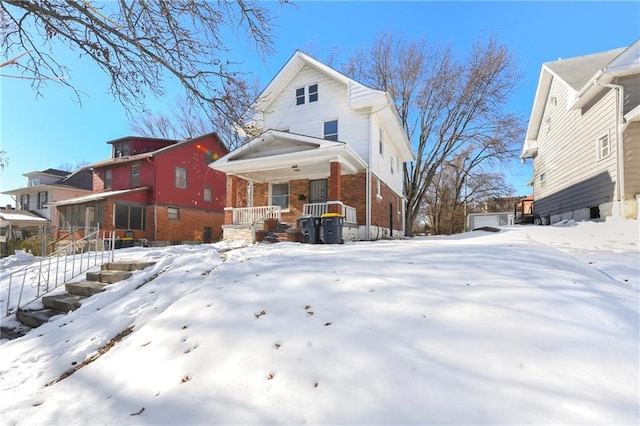 snow covered property featuring covered porch