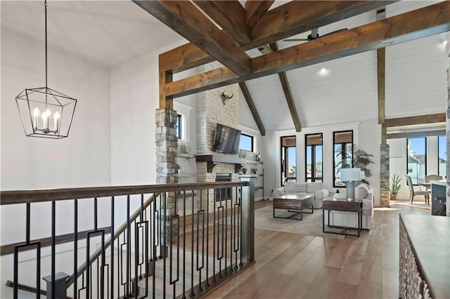 interior space featuring hardwood / wood-style floors, beam ceiling, high vaulted ceiling, and an inviting chandelier