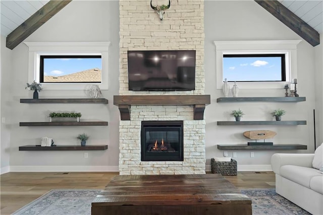 living room with vaulted ceiling with beams, a fireplace, and wood-type flooring