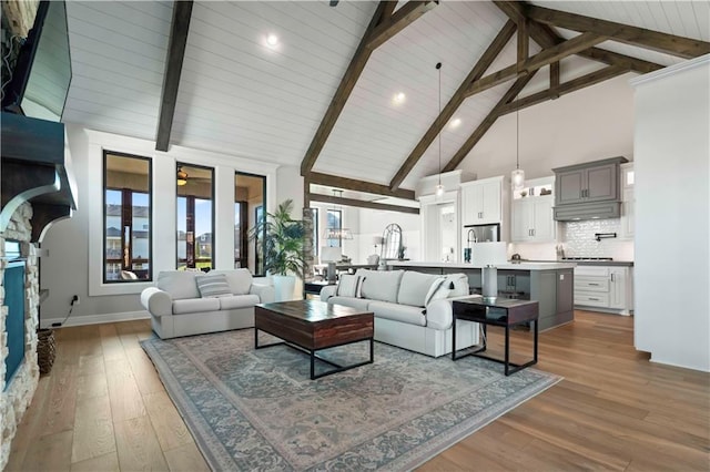 living room with ceiling fan, hardwood / wood-style floors, high vaulted ceiling, and beamed ceiling