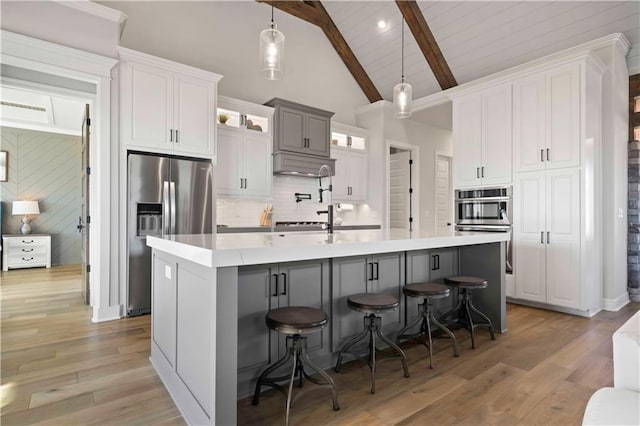 kitchen featuring a breakfast bar, white cabinets, and stainless steel appliances