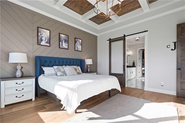 bedroom with coffered ceiling, ensuite bathroom, crown molding, light hardwood / wood-style flooring, and a barn door