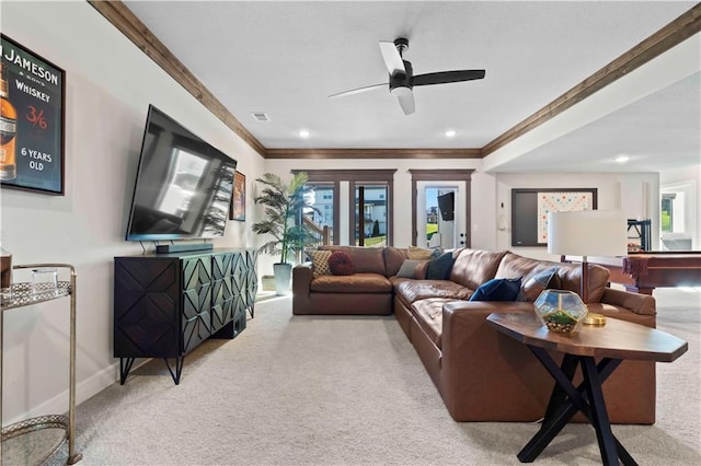 living room featuring ceiling fan, light colored carpet, and ornamental molding