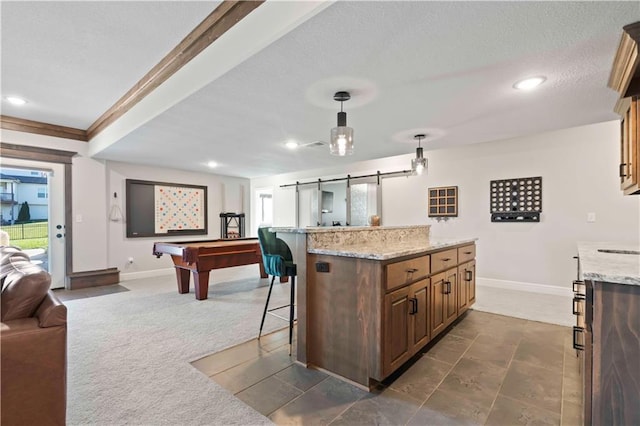 kitchen featuring dark colored carpet, a kitchen breakfast bar, billiards, a barn door, and decorative light fixtures