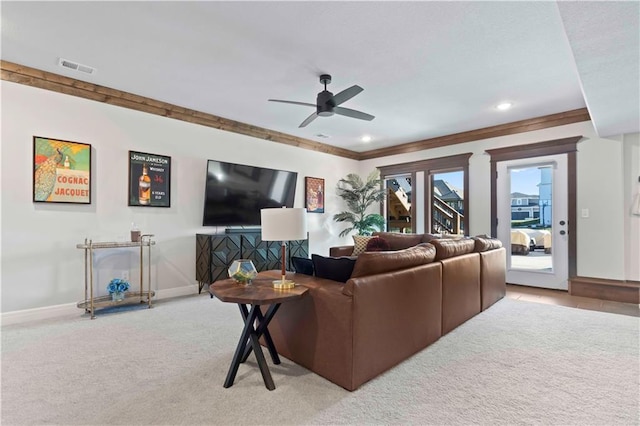 carpeted living room with ceiling fan and ornamental molding