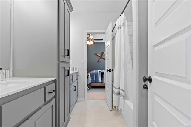 bathroom featuring tile patterned floors, ceiling fan, vanity, and shower / tub combo with curtain