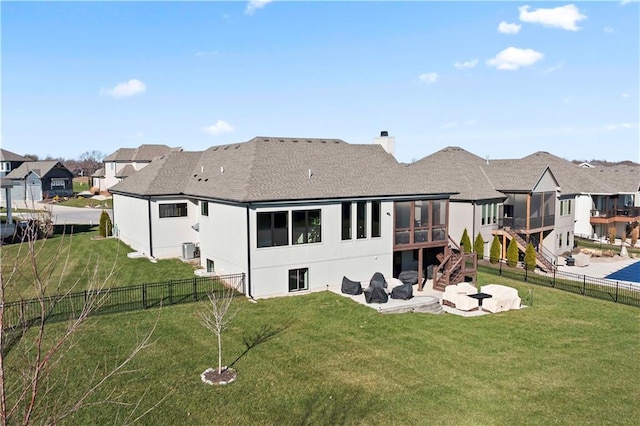 rear view of house featuring a lawn, a patio area, and a sunroom