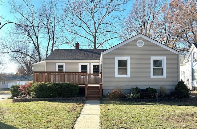 view of front of home with a deck and a front lawn