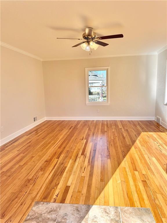 unfurnished room with ceiling fan, light hardwood / wood-style floors, and ornamental molding