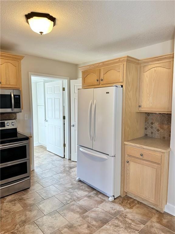 kitchen with appliances with stainless steel finishes, backsplash, a textured ceiling, and light brown cabinetry