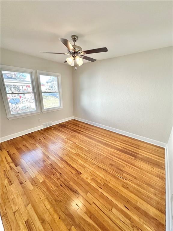 spare room featuring light wood-type flooring and ceiling fan