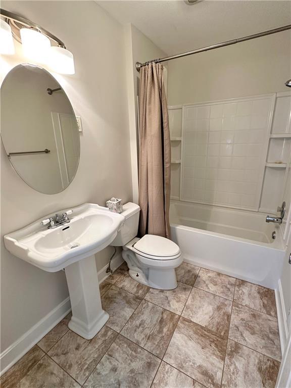 bathroom with shower / tub combo and toilet