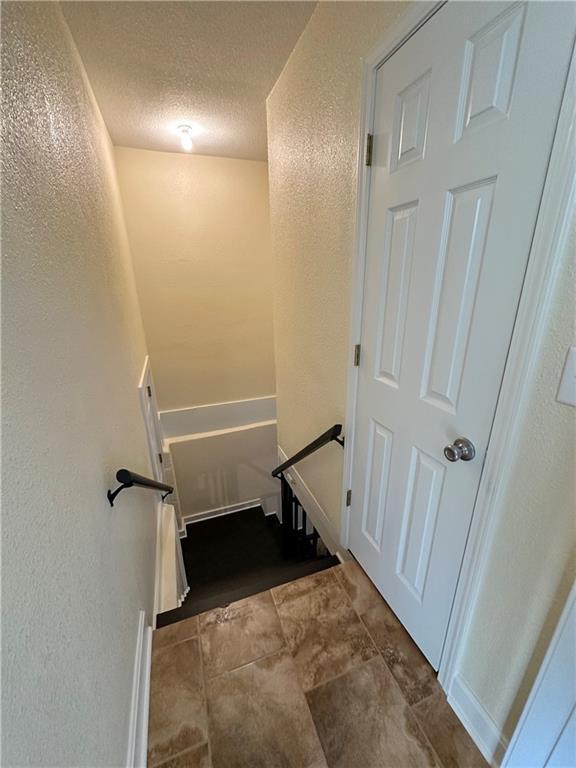 staircase featuring a textured ceiling