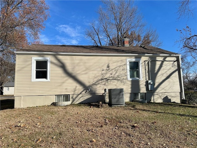 rear view of house featuring a yard and central AC unit