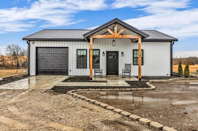 modern farmhouse style home featuring a garage, concrete driveway, and metal roof