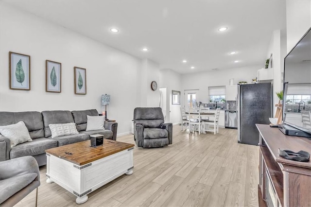 living area with light wood finished floors and recessed lighting