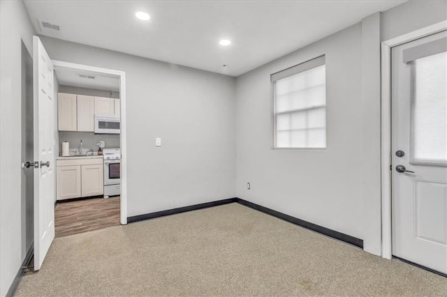 empty room featuring baseboards, visible vents, and recessed lighting