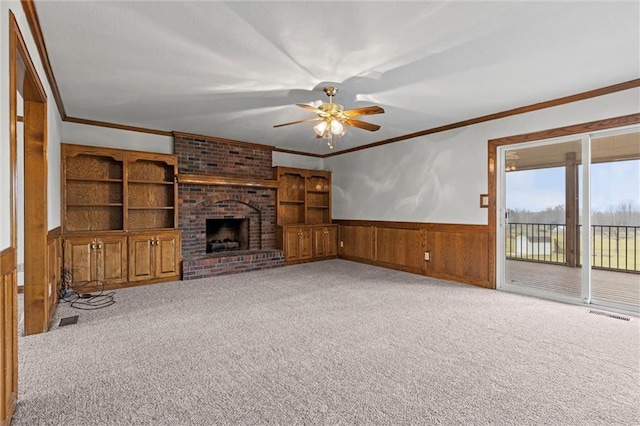 unfurnished living room featuring carpet flooring, ornamental molding, and a brick fireplace