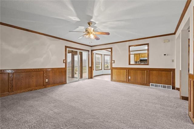 unfurnished living room with light carpet, ceiling fan, and ornamental molding