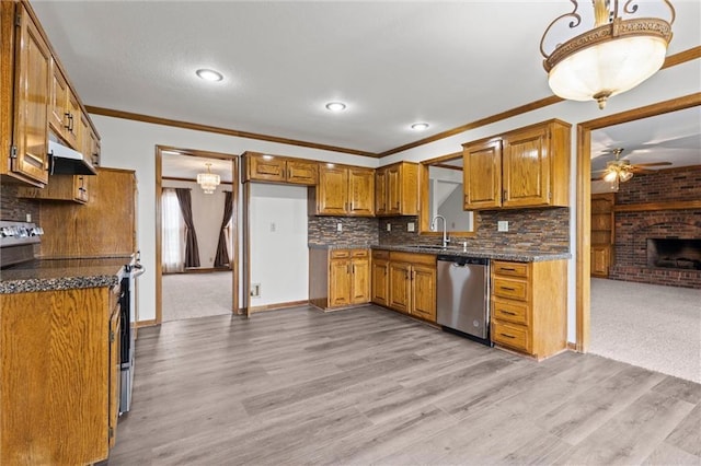 kitchen with tasteful backsplash, stainless steel appliances, ceiling fan, a fireplace, and light hardwood / wood-style floors