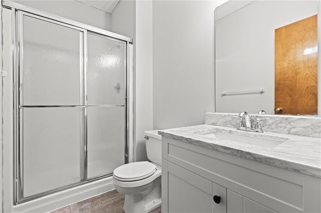 bathroom featuring vanity, toilet, and an enclosed shower