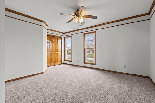 empty room with carpet, ceiling fan, and ornamental molding