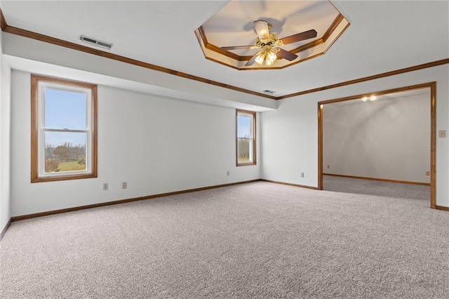 unfurnished room featuring light carpet, a tray ceiling, ceiling fan, and ornamental molding