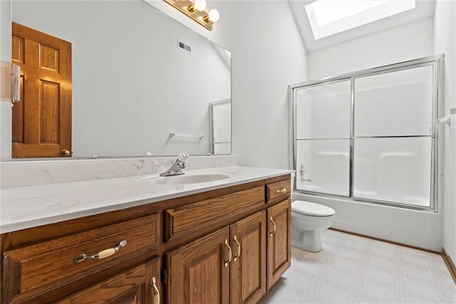 full bathroom featuring vanity, toilet, bath / shower combo with glass door, and a skylight