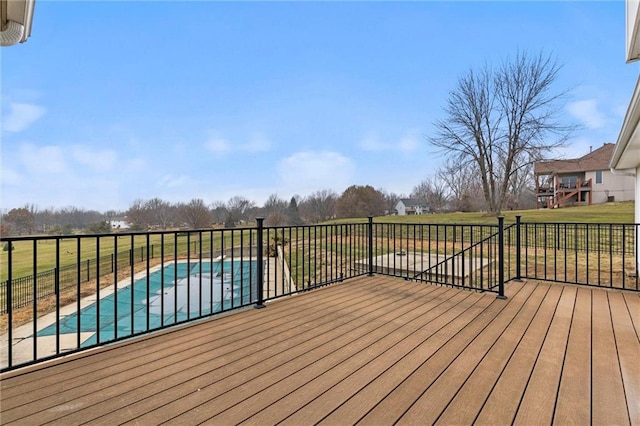 wooden terrace featuring a lawn and a covered pool