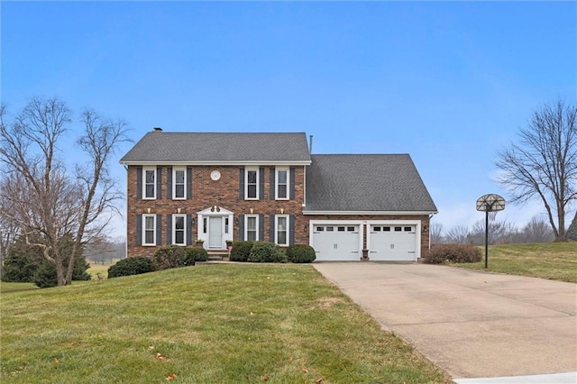 colonial inspired home with an attached garage, brick siding, concrete driveway, and a front yard