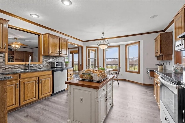 kitchen featuring appliances with stainless steel finishes, backsplash, a sink, and light wood-style floors