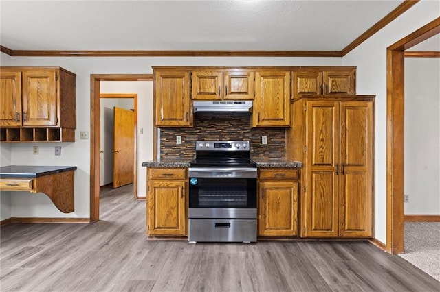 kitchen featuring dark countertops, stainless steel range with electric stovetop, under cabinet range hood, and brown cabinets