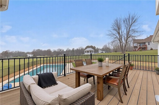 wooden terrace featuring a yard, outdoor dining space, an outdoor living space, and a fenced in pool