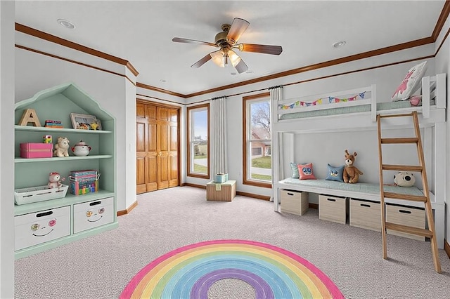 recreation room featuring ceiling fan, carpet floors, baseboards, and crown molding