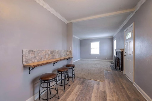 interior space featuring hardwood / wood-style floors, indoor bar, and ornamental molding