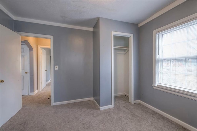 unfurnished bedroom featuring light colored carpet and a closet