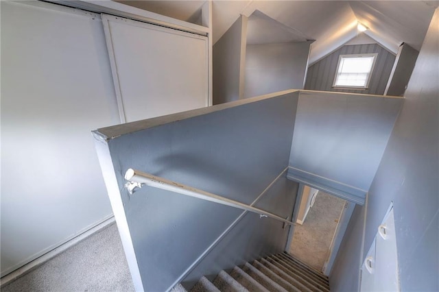 stairway with carpet flooring and lofted ceiling