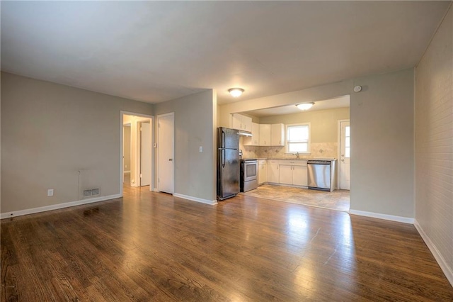 unfurnished living room featuring sink and dark wood-type flooring