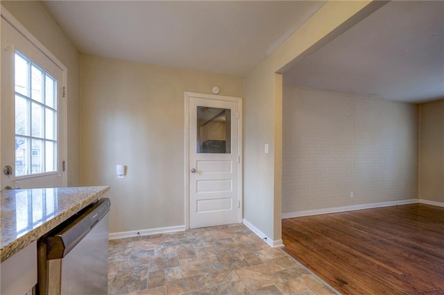 interior space with light stone counters and stainless steel dishwasher