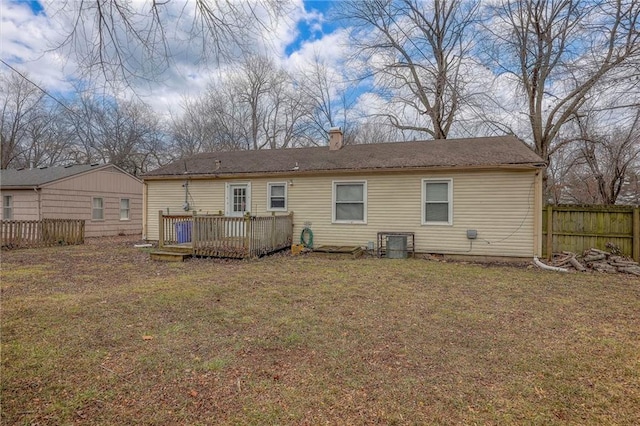 back of property featuring a lawn and a deck