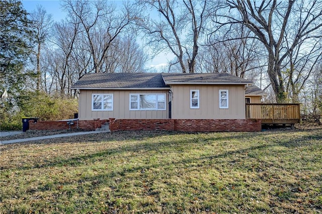 rear view of house with a lawn and a deck