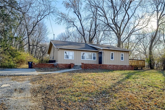 ranch-style home with a wooden deck and a front yard