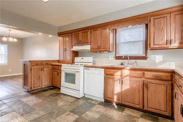 kitchen with a notable chandelier, decorative light fixtures, white appliances, and sink