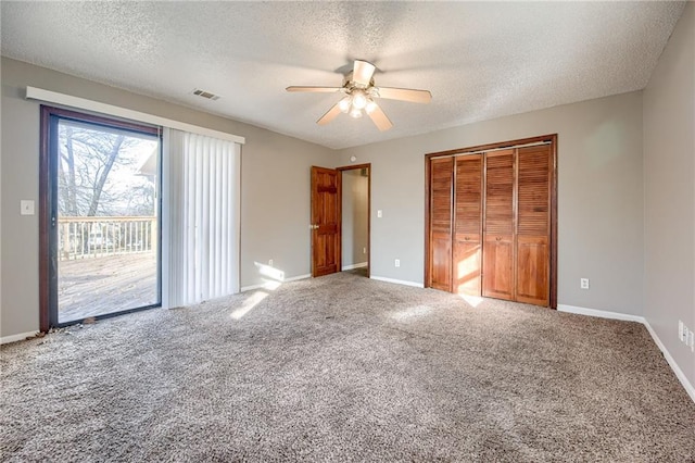 unfurnished bedroom featuring carpet, a textured ceiling, and ceiling fan