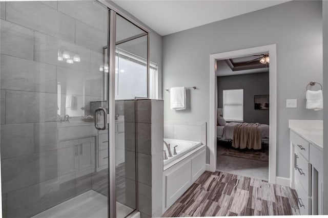 bathroom with ceiling fan, vanity, a shower stall, ensuite bath, and a bath