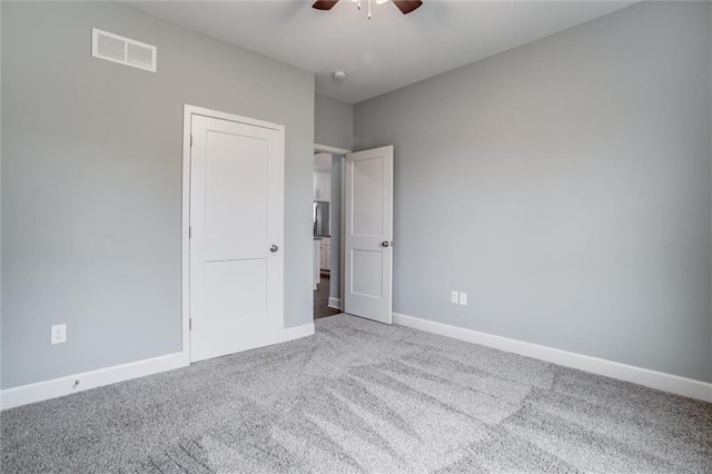 unfurnished bedroom featuring visible vents, carpet flooring, baseboards, and ceiling fan