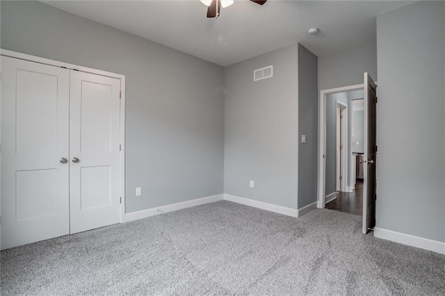 unfurnished bedroom featuring visible vents, baseboards, carpet flooring, a closet, and a ceiling fan