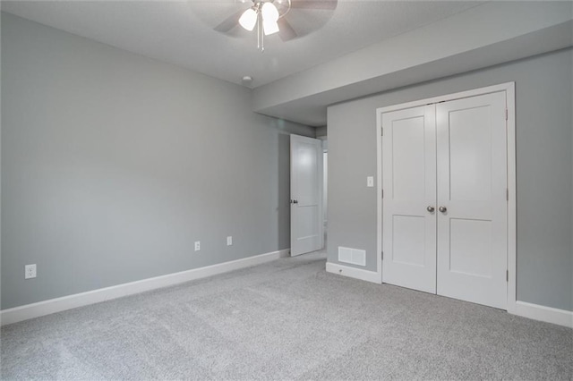 unfurnished bedroom featuring light carpet, visible vents, baseboards, a ceiling fan, and a closet