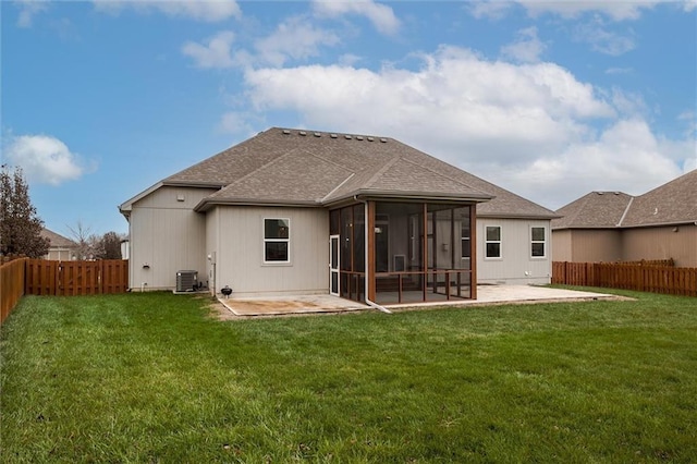 rear view of property featuring a yard, a sunroom, a fenced backyard, and a patio